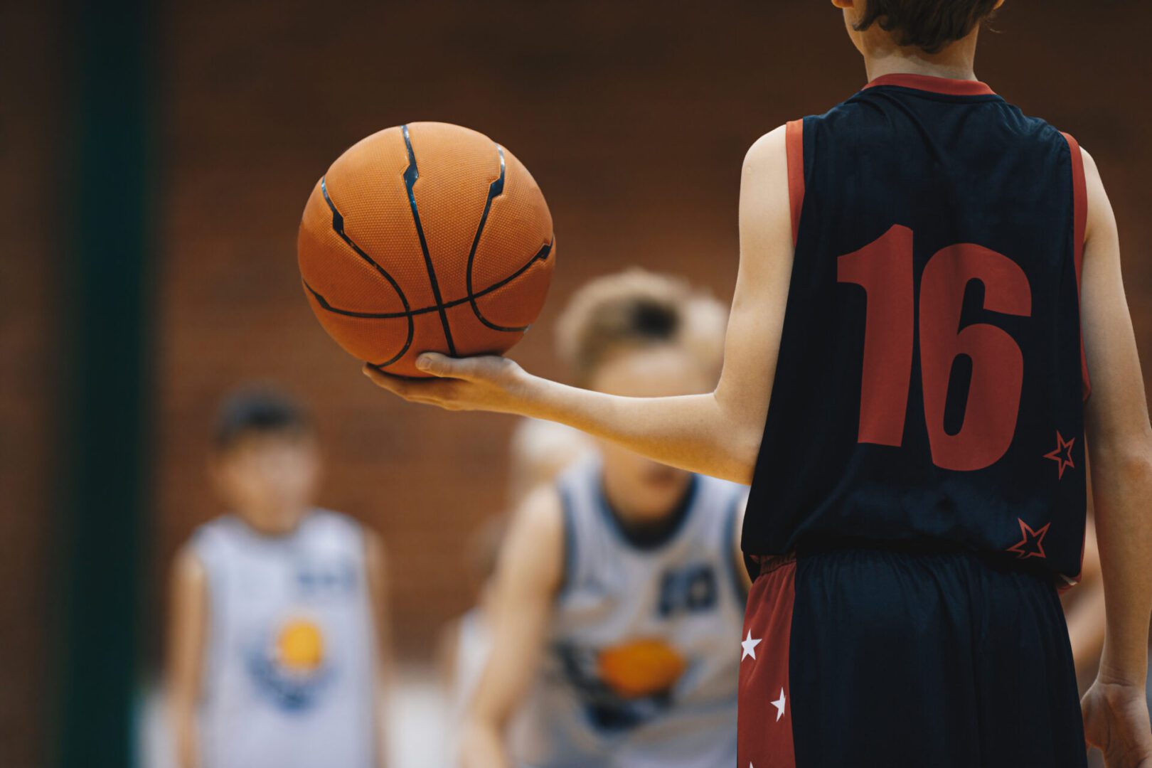 Basketball player holding ball on court.