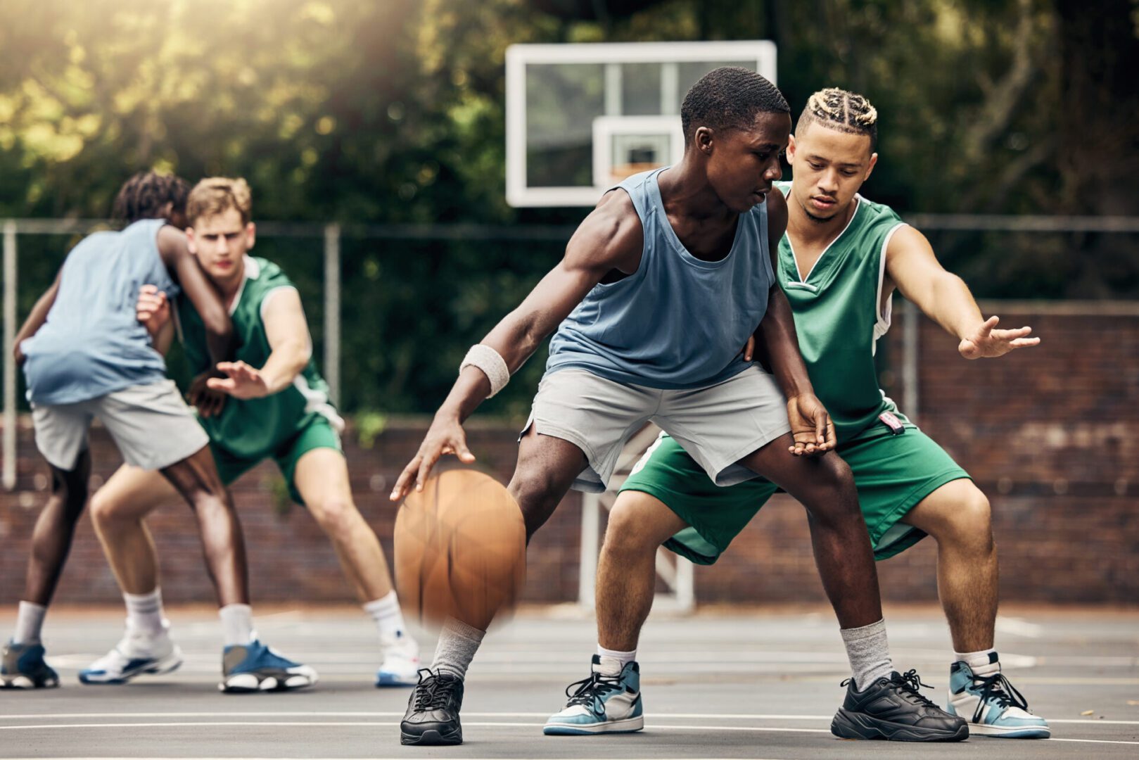 Basketball players competing on outdoor court.