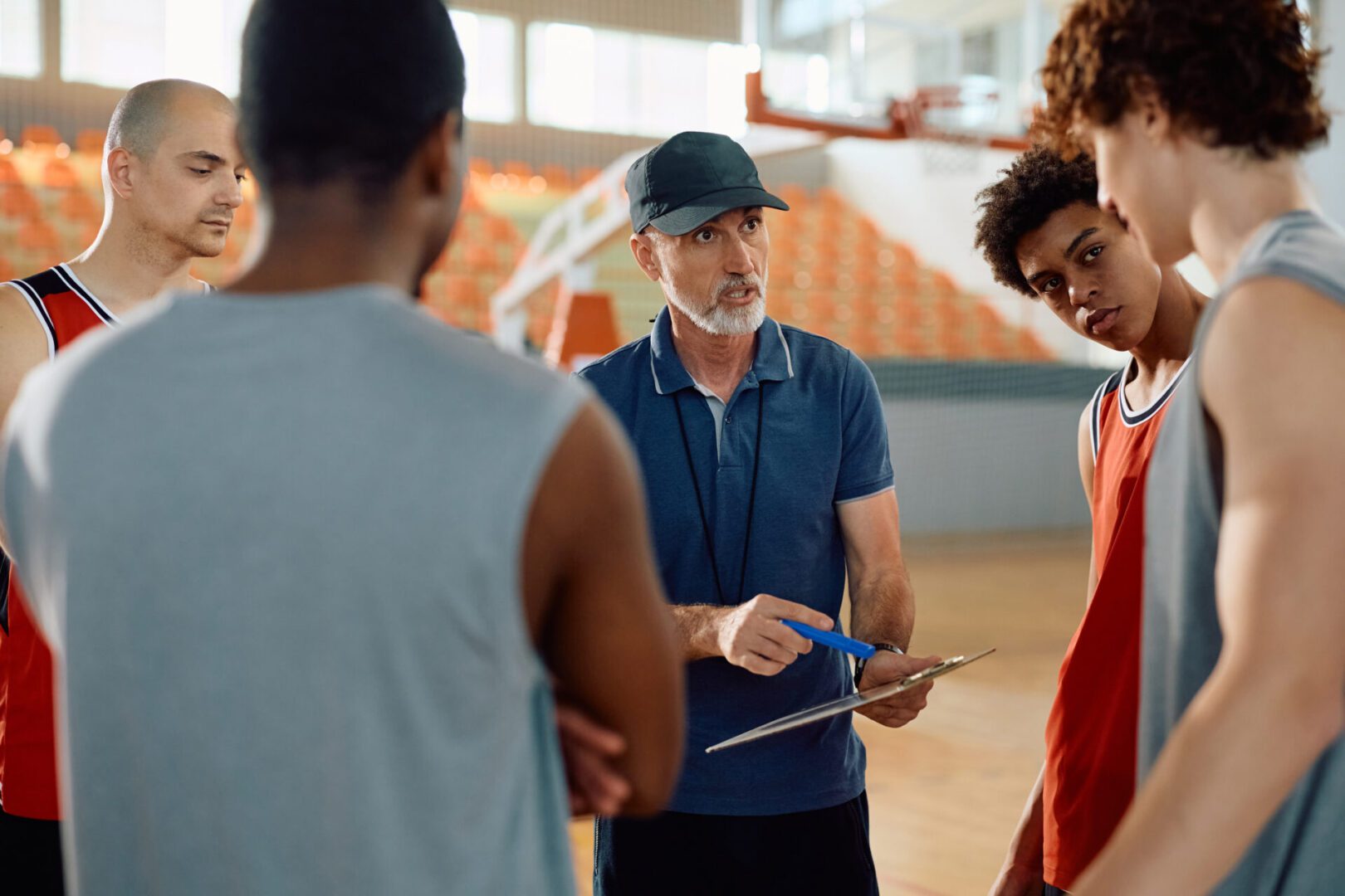 Basketball coach instructing players during practice.