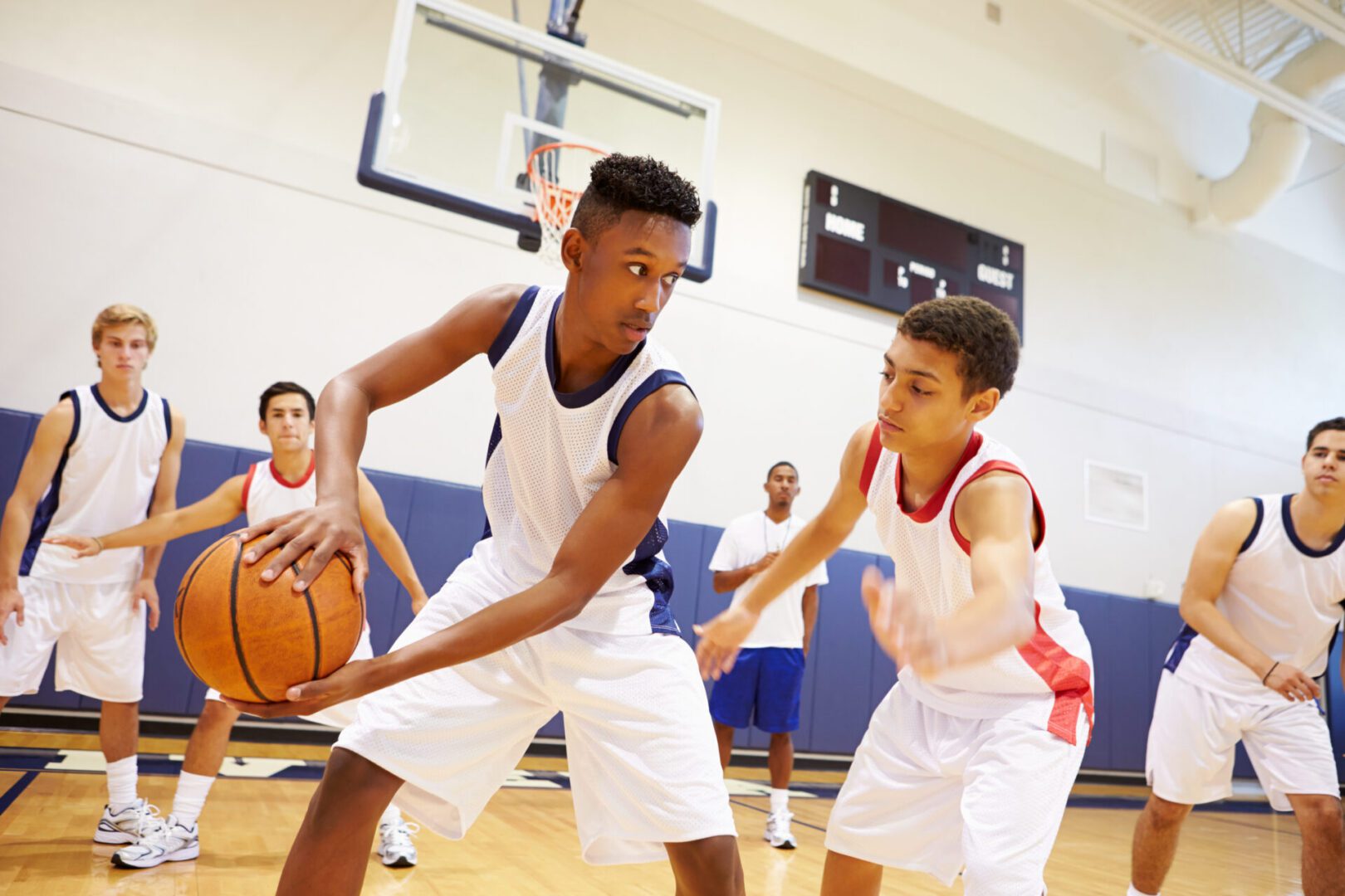Basketball players in action on indoor court.